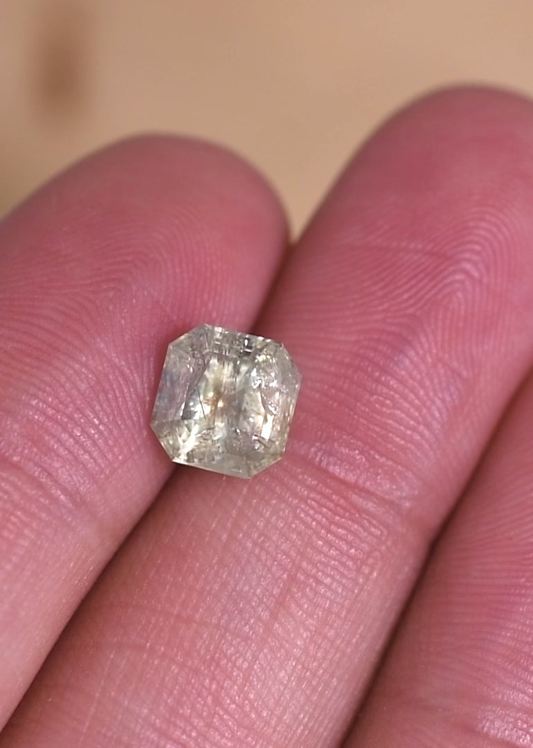 Macro video of a natural Montana sapphire Asscher cut under shifting light, demonstrating seafoam and teal color play, internal crystal structure, and the depth of an unheated 2.25 carat sapphire.