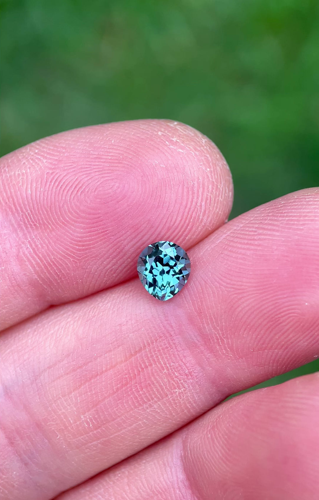 Natural light video of a 1.02ct Montana sapphire, showcasing vibrant teal, blue, and green reflections.