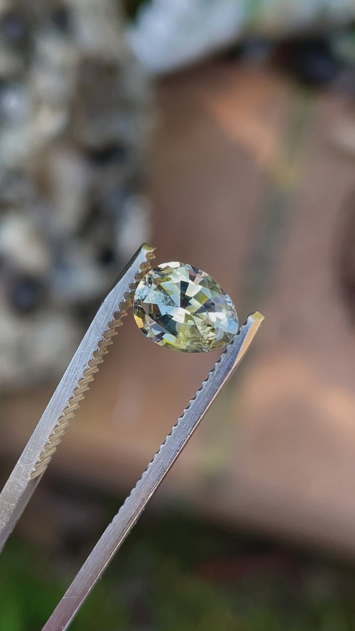 A 1.95-carat sapphire with yellow and blue parti colors, cut in a peared oval (Poval) shape, displayed in motion to highlight its brilliance and color play. Originating from Sri Lanka, the untreated sapphire sparkles under natural light.