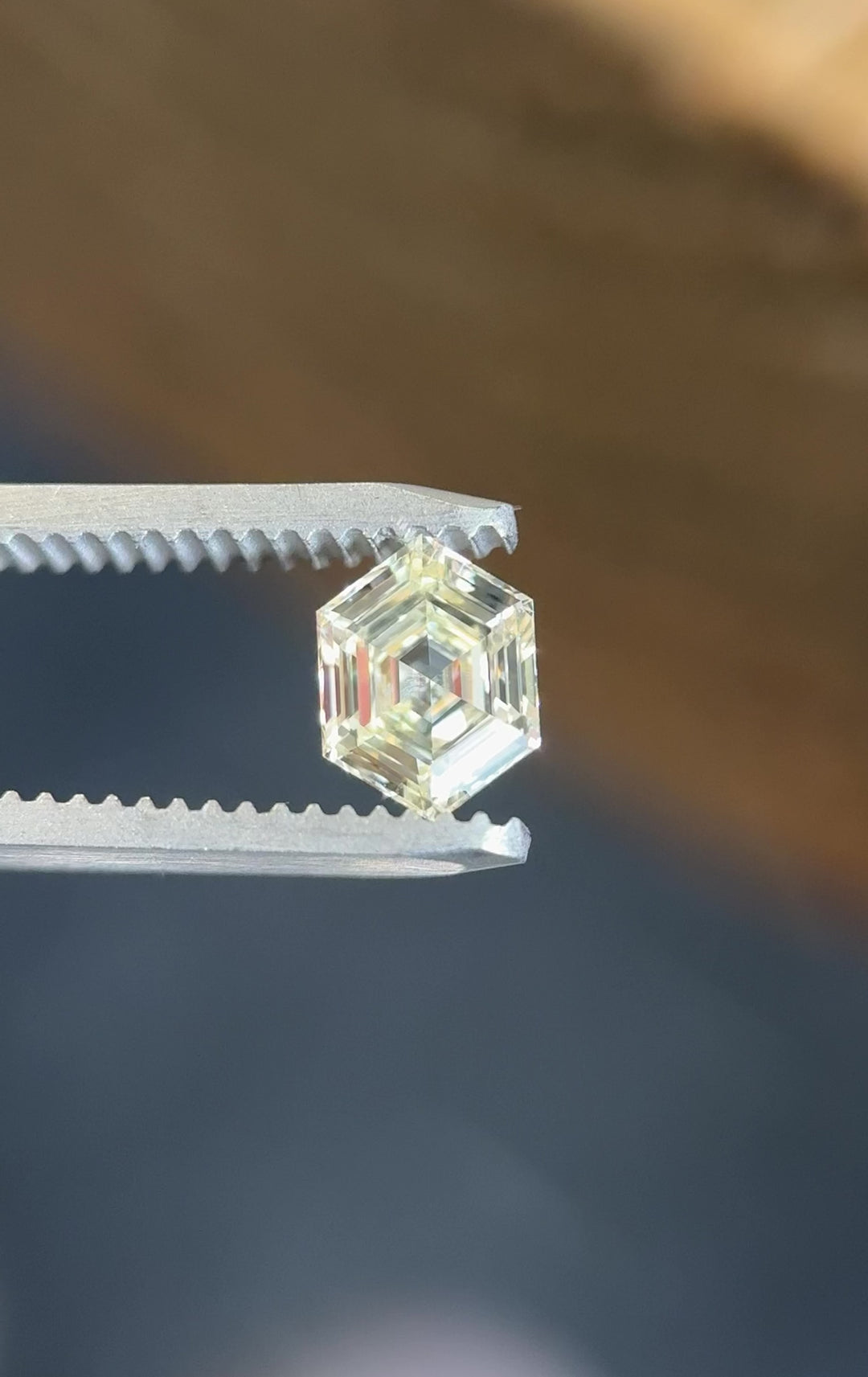Video of a 1.01 carat O–P color VVS2 clarity diamond from Gahcho Kué, Canada, rotating in tweezers to reveal the precision of its hexagonal step cut and natural brilliance.