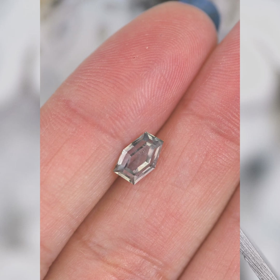1.15ct Montana sapphire rotating under studio lighting, custom geometric hexagon cut revealing purple, pink, and gray color shift and brilliance, untreated gemstone from El Dorado Bar Deposit.