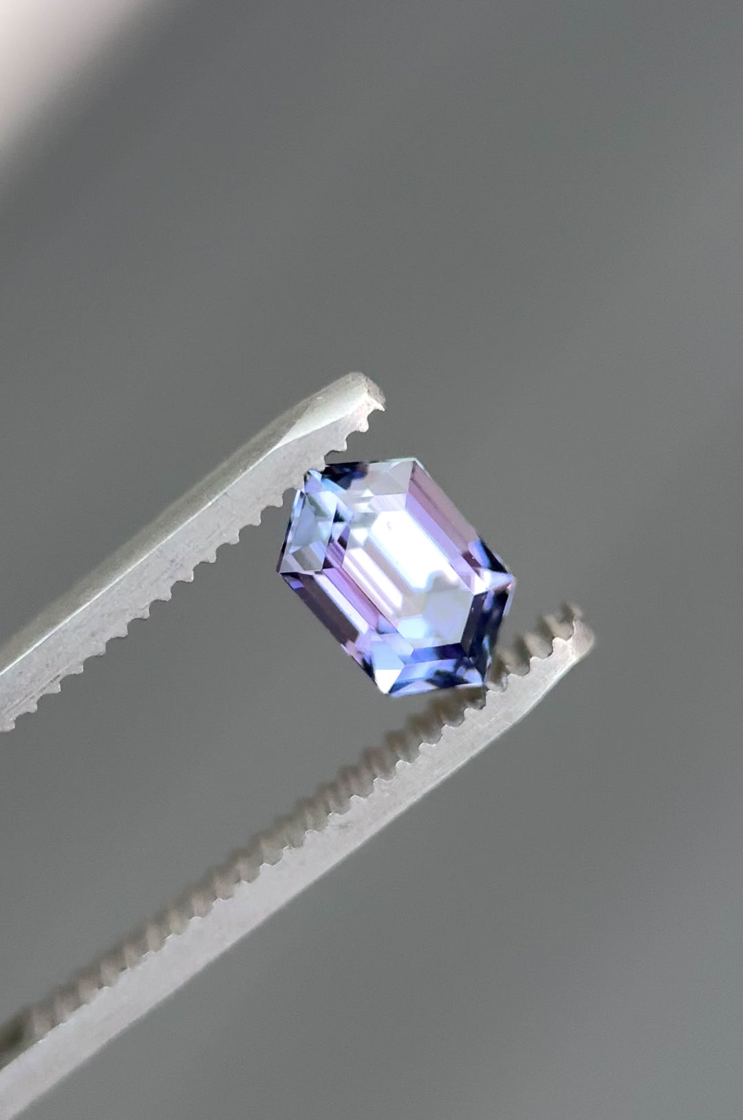 Video of a 1.43-carat step cut hexagon tanzanite being rotated under natural light, revealing shifting mermaid colors—blue, green, pink, and purple—and highlighting the gem’s untreated clarity and origin from Merelani Hills, Tanzania.