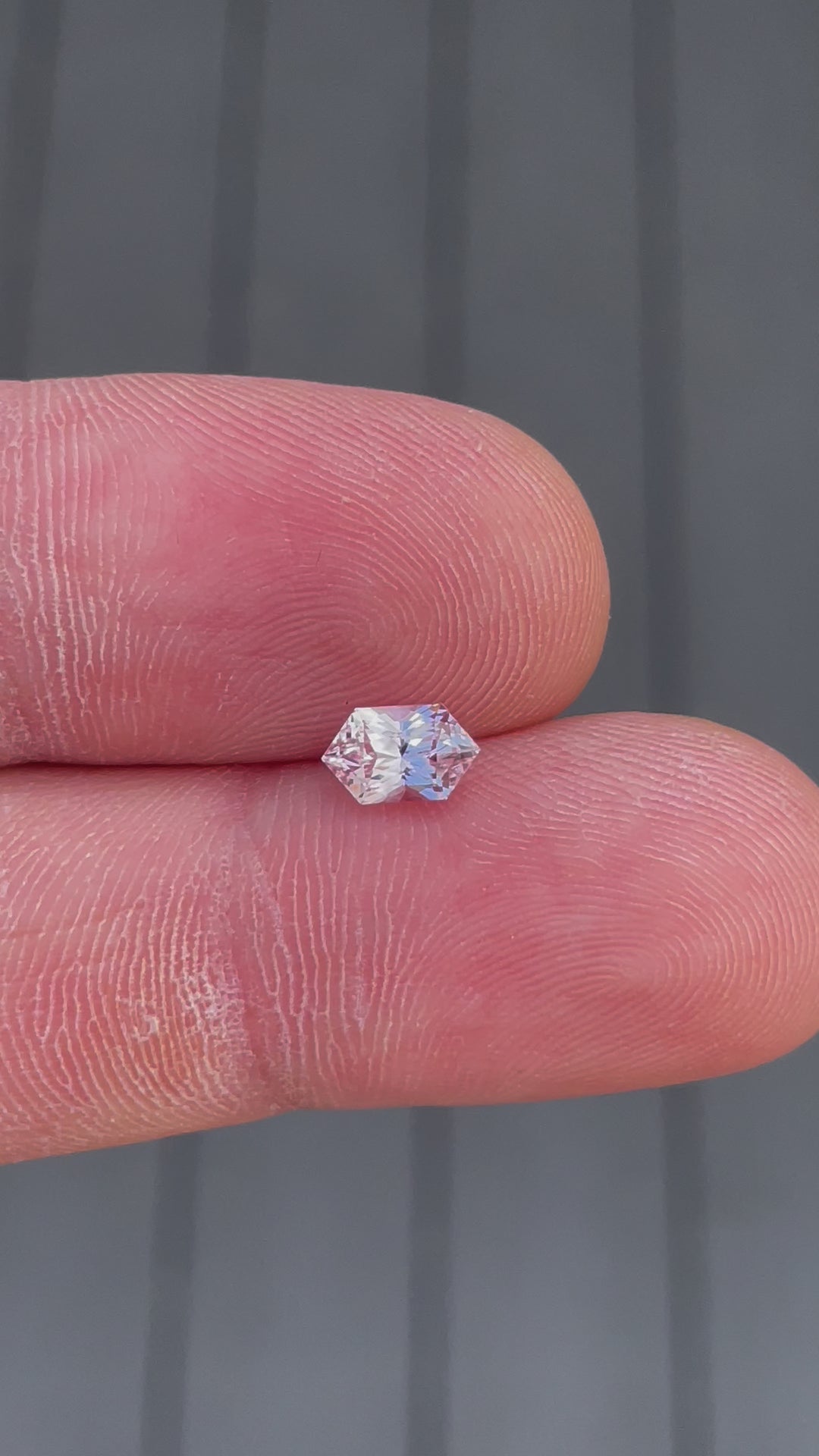 360-degree video of a 1.20 carat sapphire gemstone, hexagonal mixed cut with peach and pink hues, untreated and from Sri Lanka.