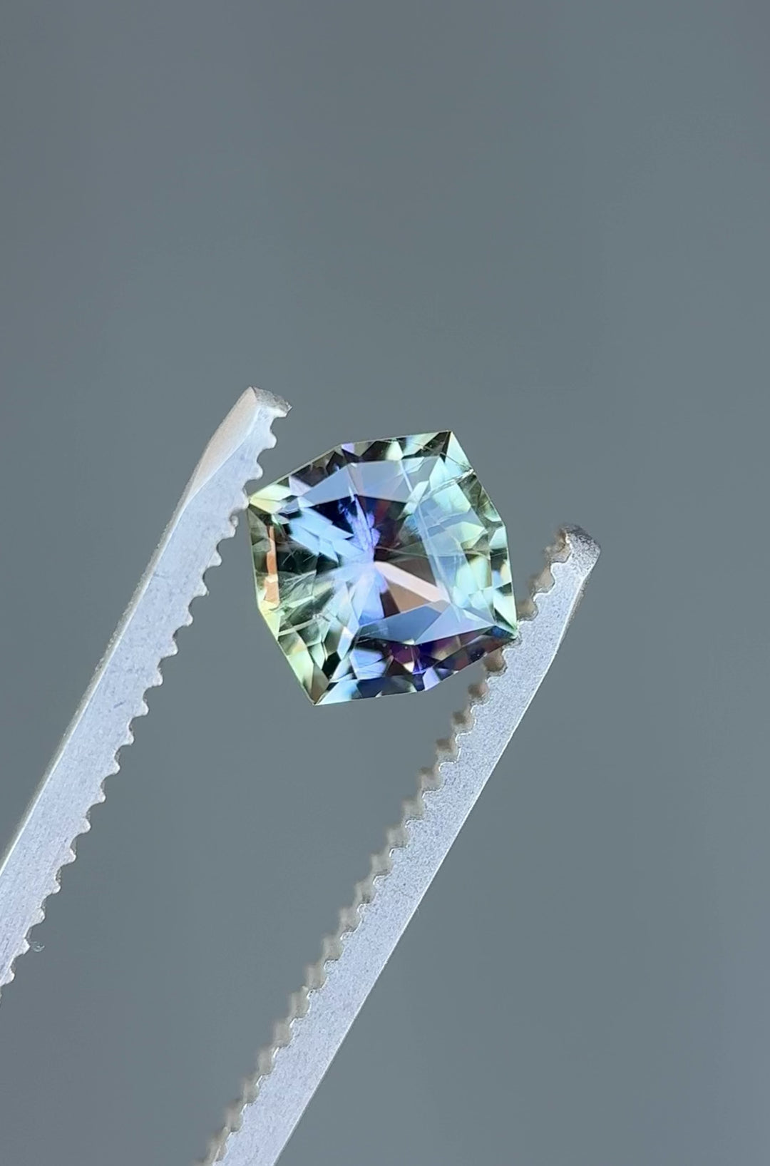 Rotating video of 1.55ct Tanzanite gemstone in custom kite cut revealing color shifts of mermaid green, teal, yellow, and purple under light