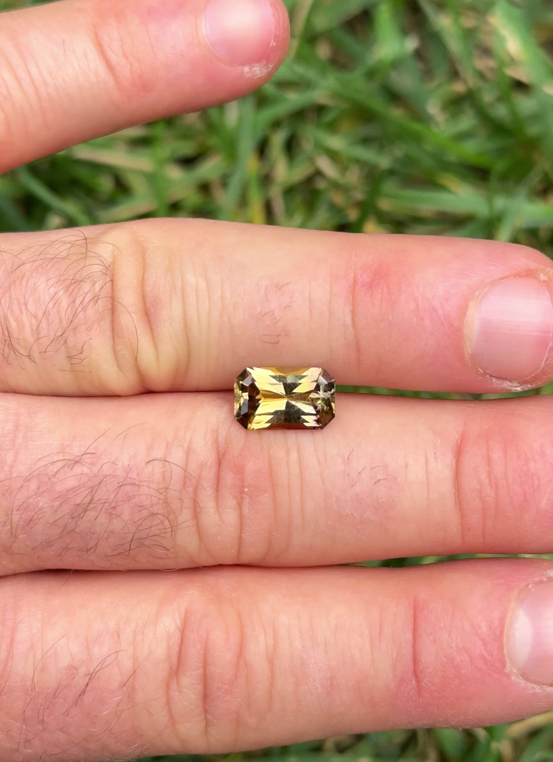 Daylight rotation video of 2.63 carat Tanzanite from Merelani Hills, Tanzania, revealing shifting tones of golden yellow, pink, and purple through its custom octagon radiant cut, untreated and natural gem.