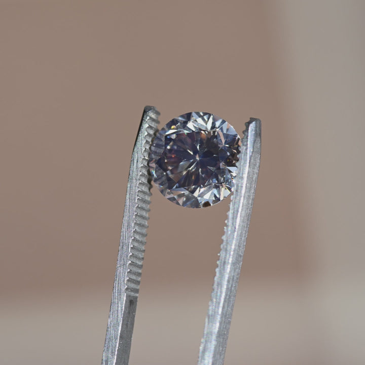 VS1  Canadian champagne diamond turned in tweezers under changing light, revealing brilliance and strong blue fluorescence character.