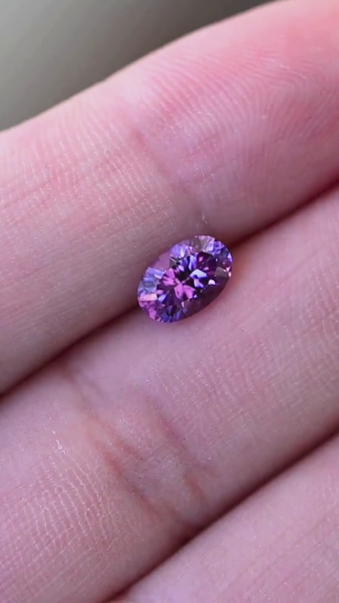 A close-up video of a natural 1.17 carat orchid purple sapphire from Sakaraha, Madagascar, shown against the hand for scale. Its fantasy oval mixed cut and lavender-violet coloration make it an intriguing option for custom engagement rings and bespoke jewelry.