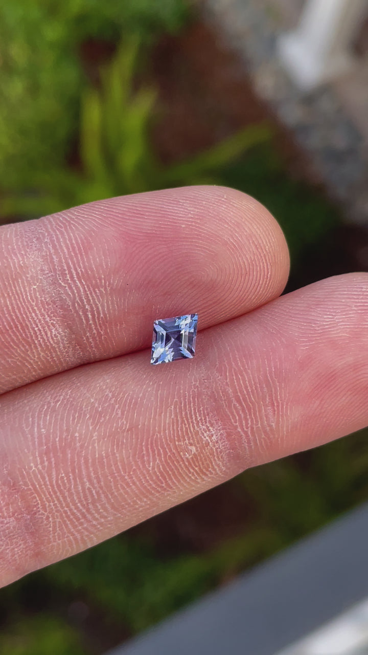 High-resolution video of a 1.53 carat kite step-cut sapphire in violet and blue hues. Ethically sourced and untreated, highlighting its intricate facets and luminous color shifts.