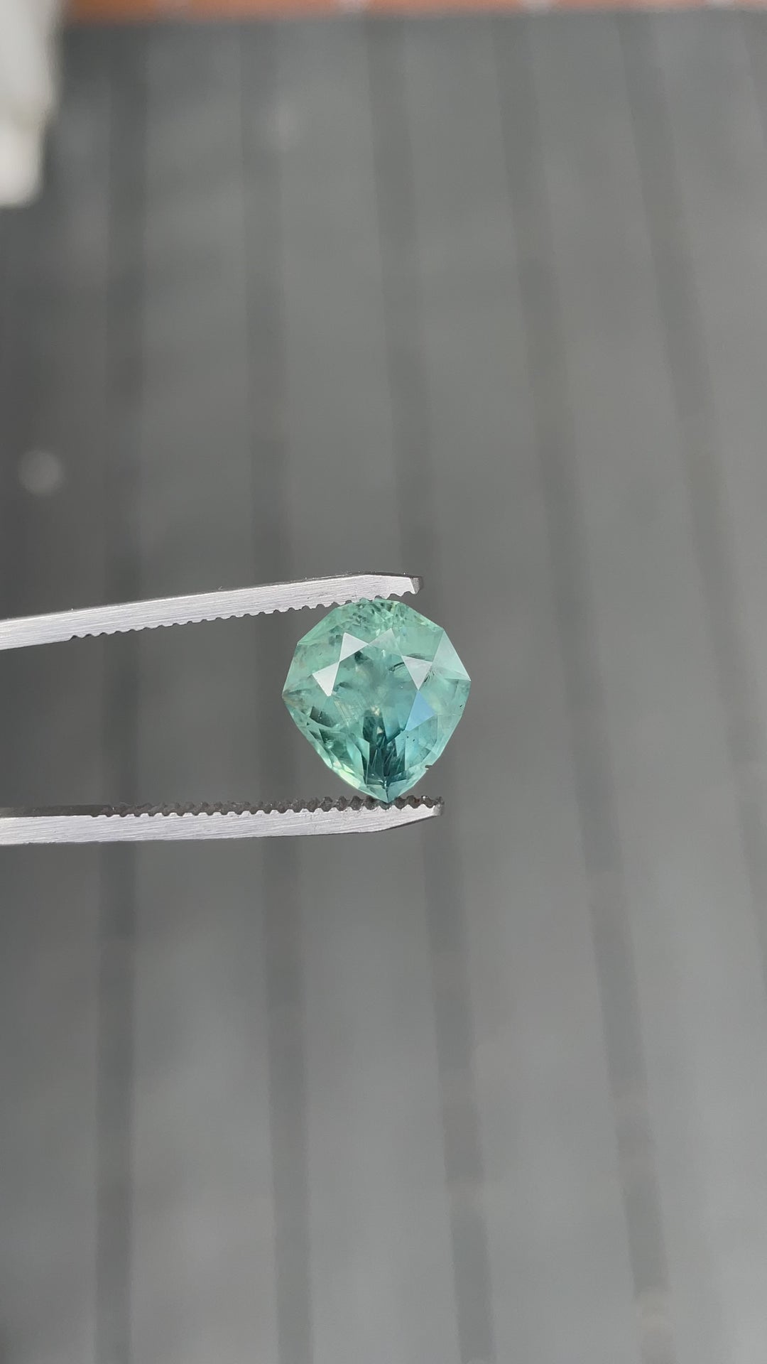Video of 7.08ct Montana sapphire in custom geometric pear shape showing silky blue, green, and teal tones.