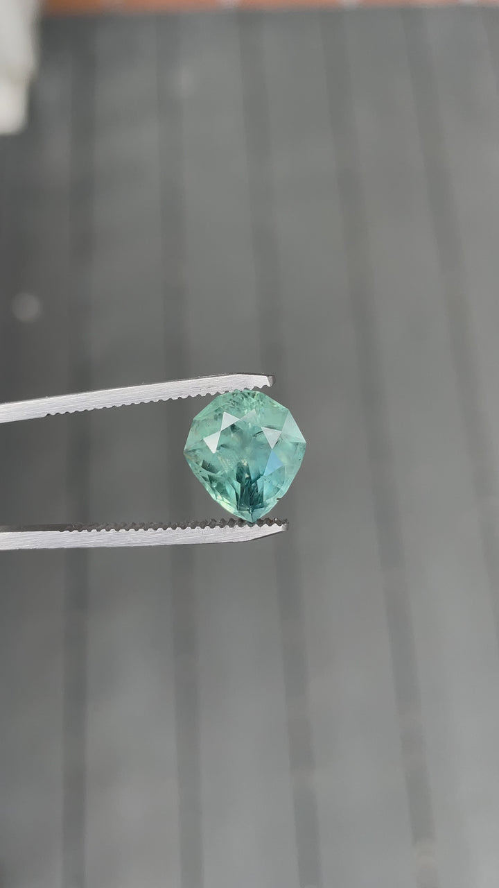 Video of 7.08ct Montana sapphire in custom geometric pear shape showing silky blue, green, and teal tones.