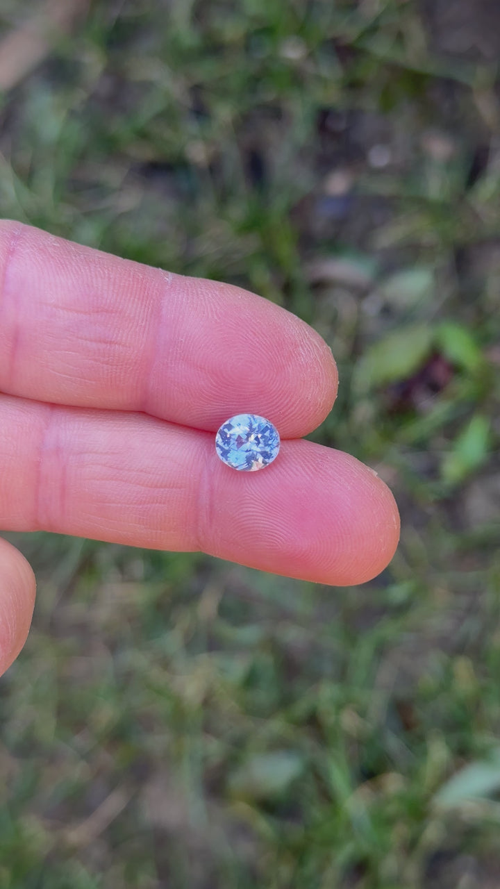 Opalescent cornflower blue oval sapphire rotated in natural light, revealing shifting pastel blue flashes, crisp facet reflections, and a soft glowing internal diffusion typical of unheated stones.