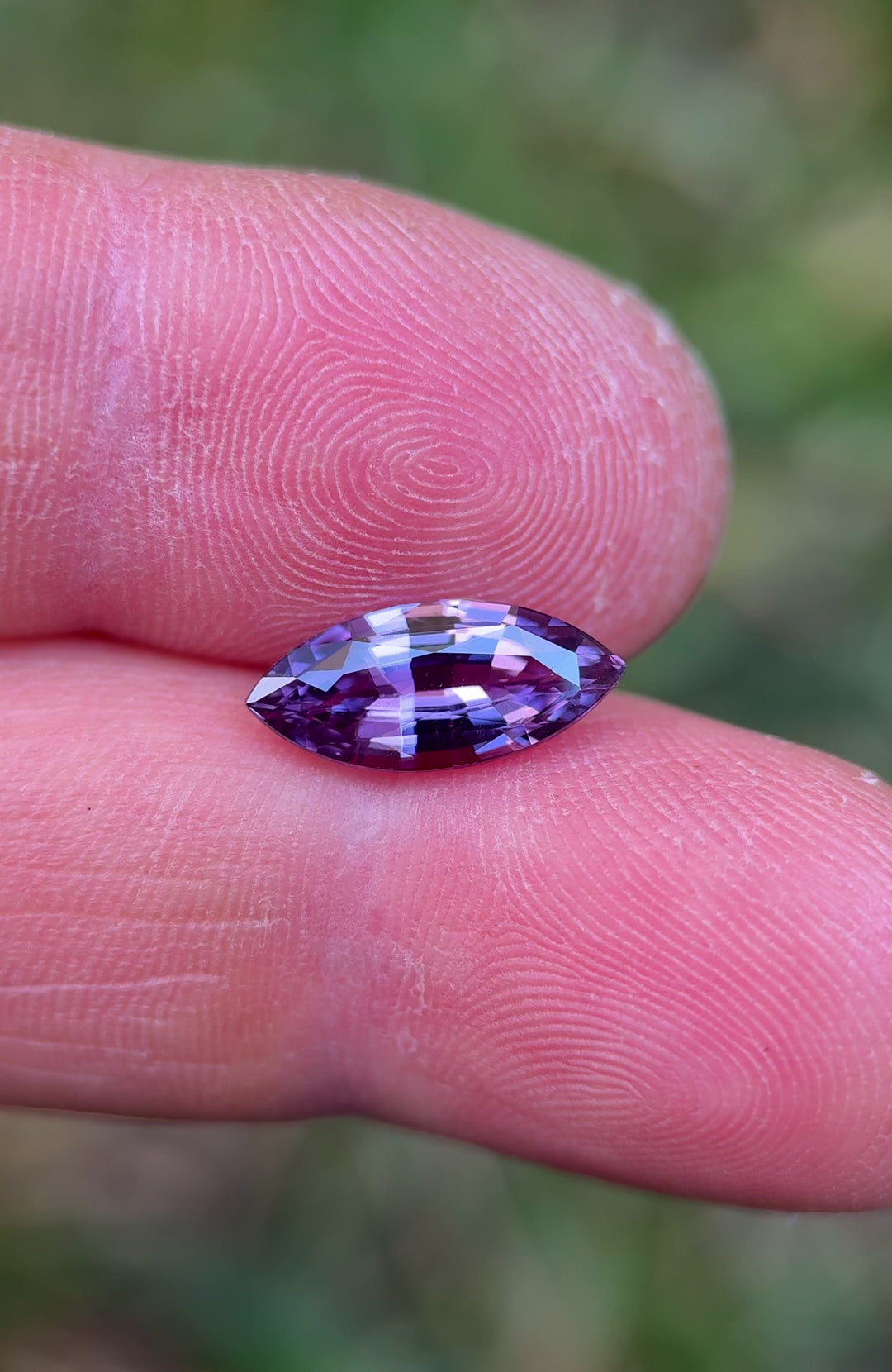 Video of 3.06 carat marquise brilliant cut sapphire from Madagascar, showing vibrant pink and purple color shifts and high clarity under natural light.