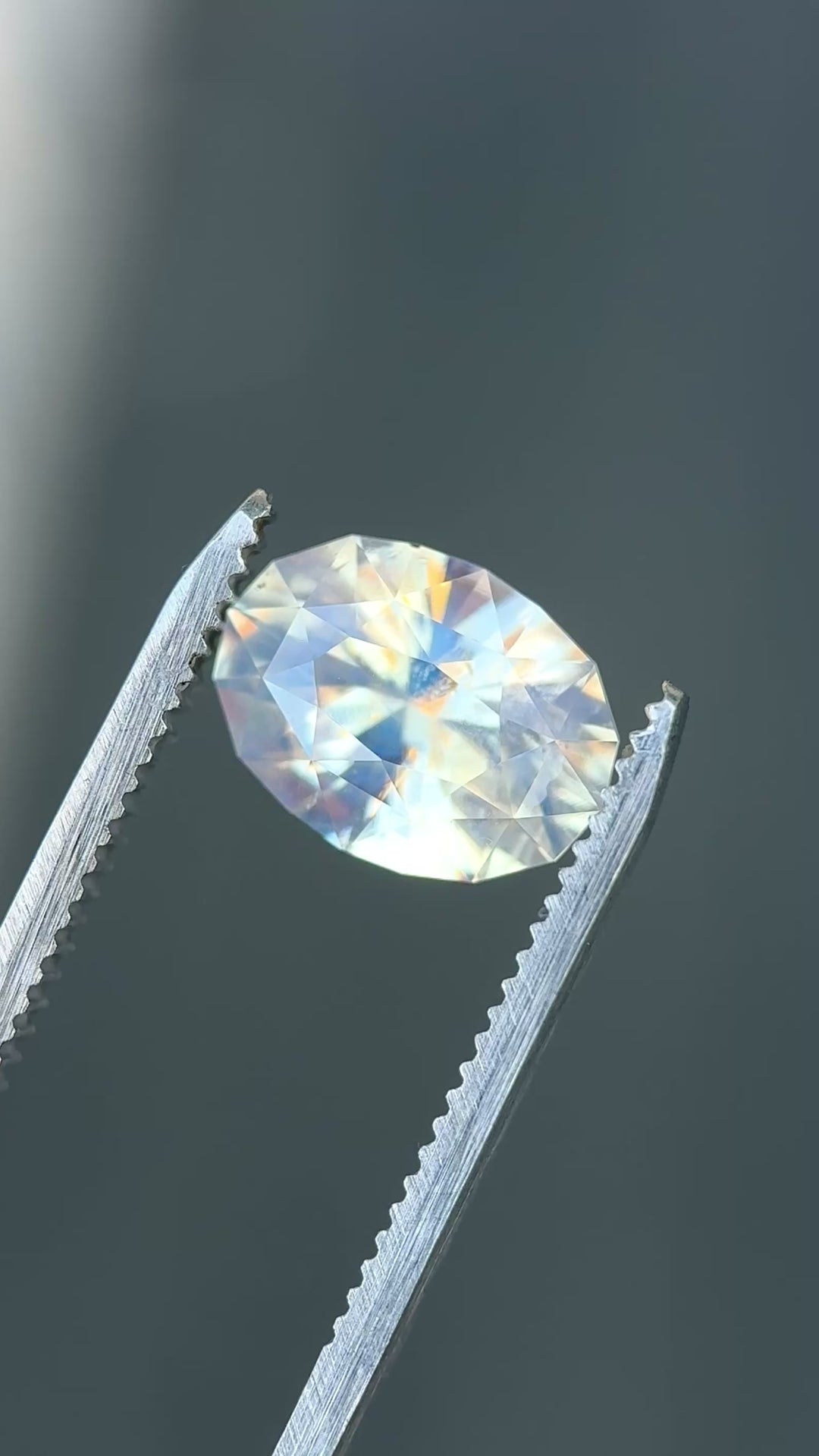 Large opalescent seafoam sapphire rotating in light showing soft glow and shifting off white and green tones.