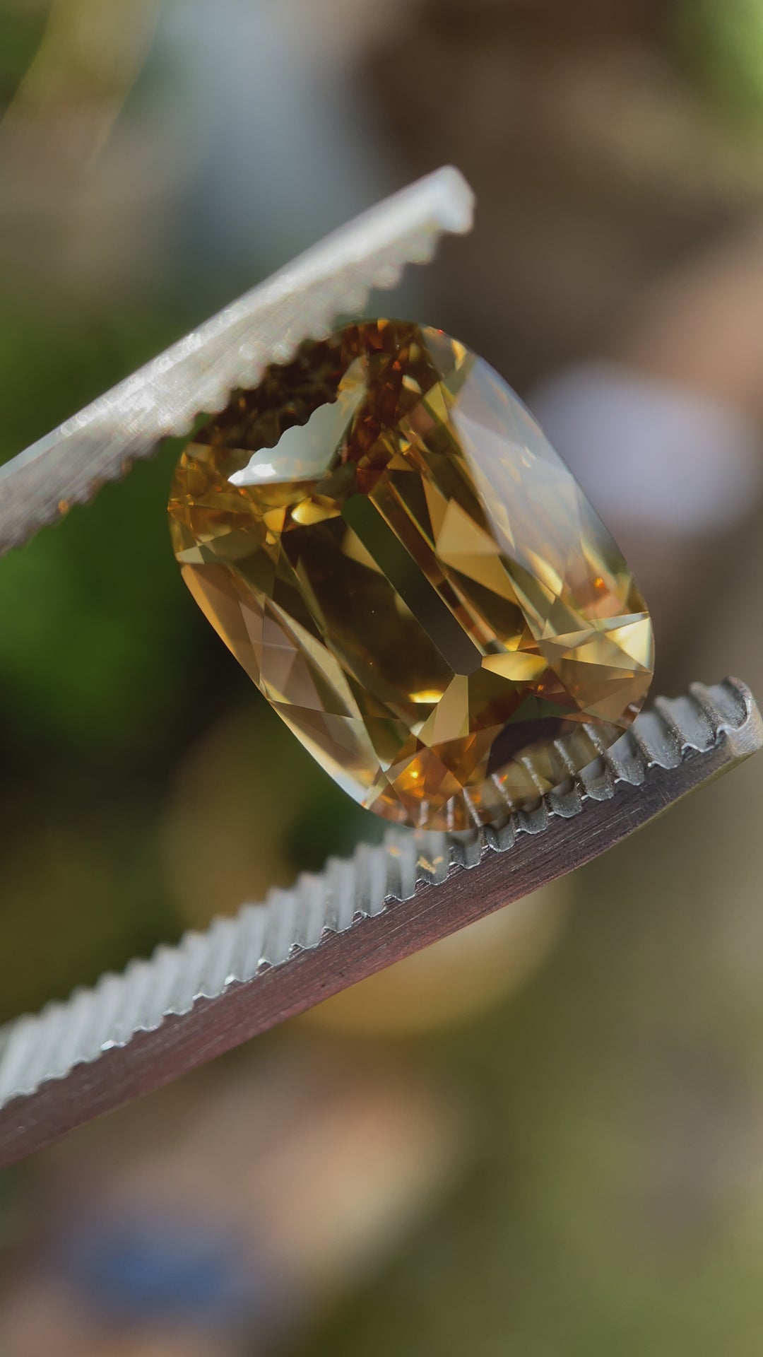 A stunning 3.51-carat Natural Fancy Brown-Yellow Diamond, featuring a Modern Antique Cushion Cut, held in precision tweezers under natural lighting. The video highlights the diamond's warm golden-brown tones, exceptional VS1 clarity, and expertly faceted shape, enhancing its brilliance and fire.