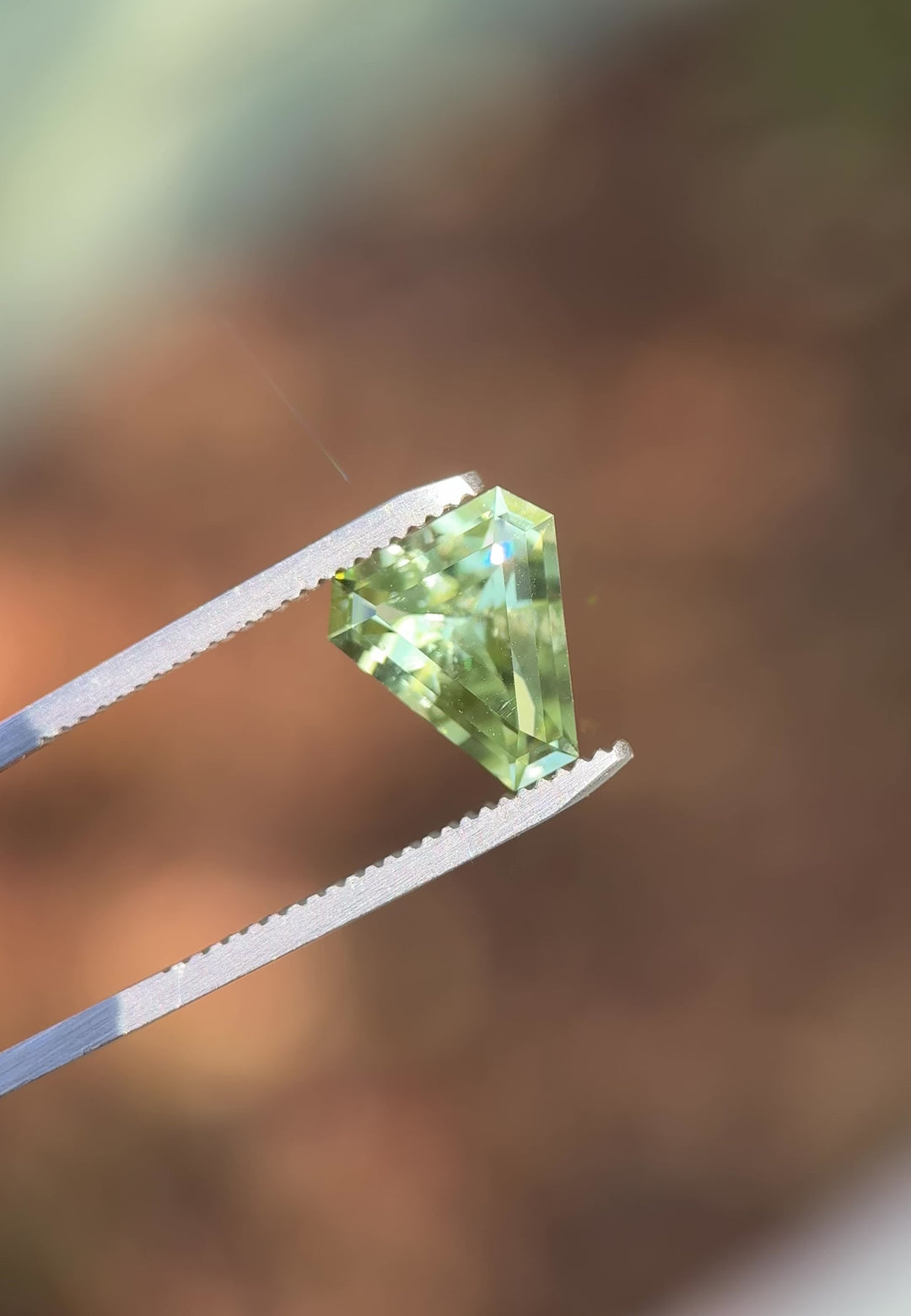 Rotating video of 3.26 carat mint green tourmaline under daylight, showing custom shield step cut brilliance and soft green color transitions, untreated gem sourced from Congo, Africa.