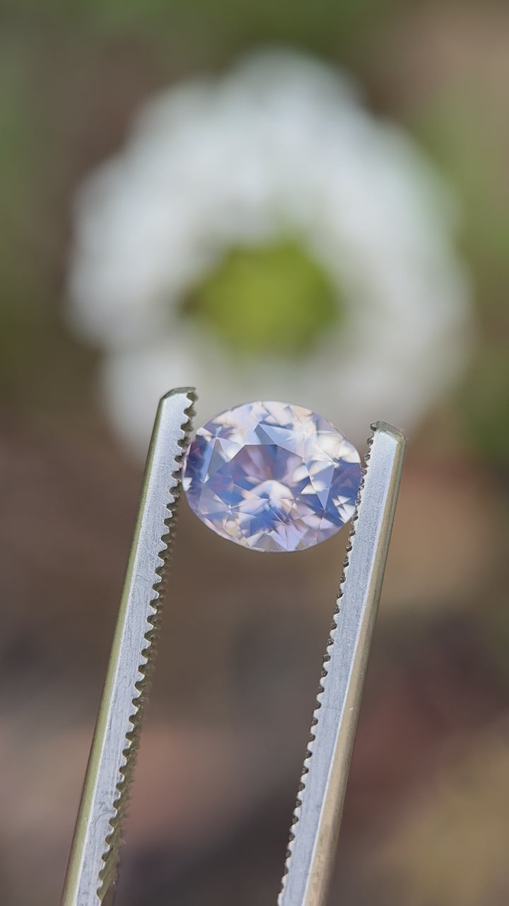 Rotating view of a 1.60-carat opalescent sapphire from Sri Lanka showing blush, lavender, and platinum hues under natural light