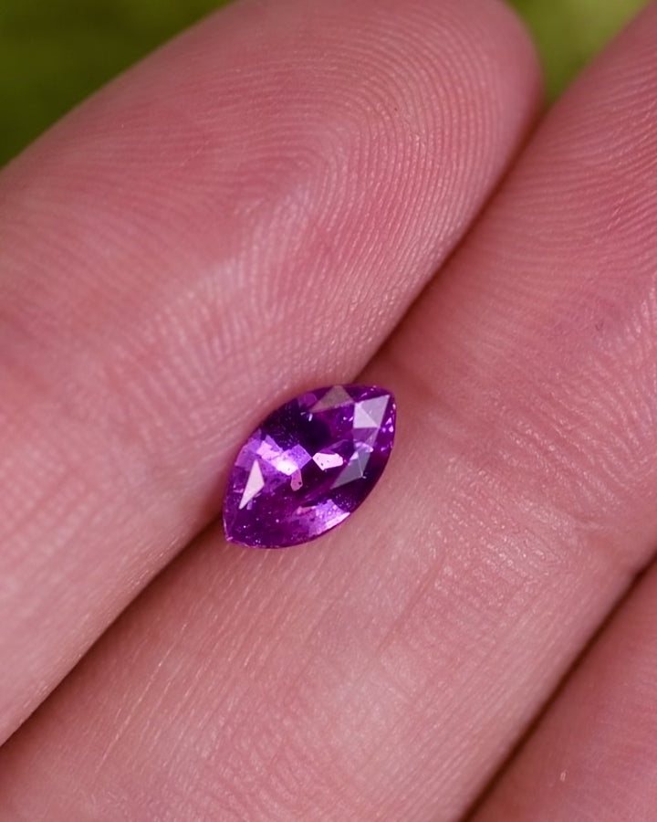 Close-up motion video of 1.01 carat purple and pink sapphire turning in natural light, showing fine brilliance and faceting detail of its marquise brilliant cut, unheated sapphire from Sakaraha, Madagascar.
