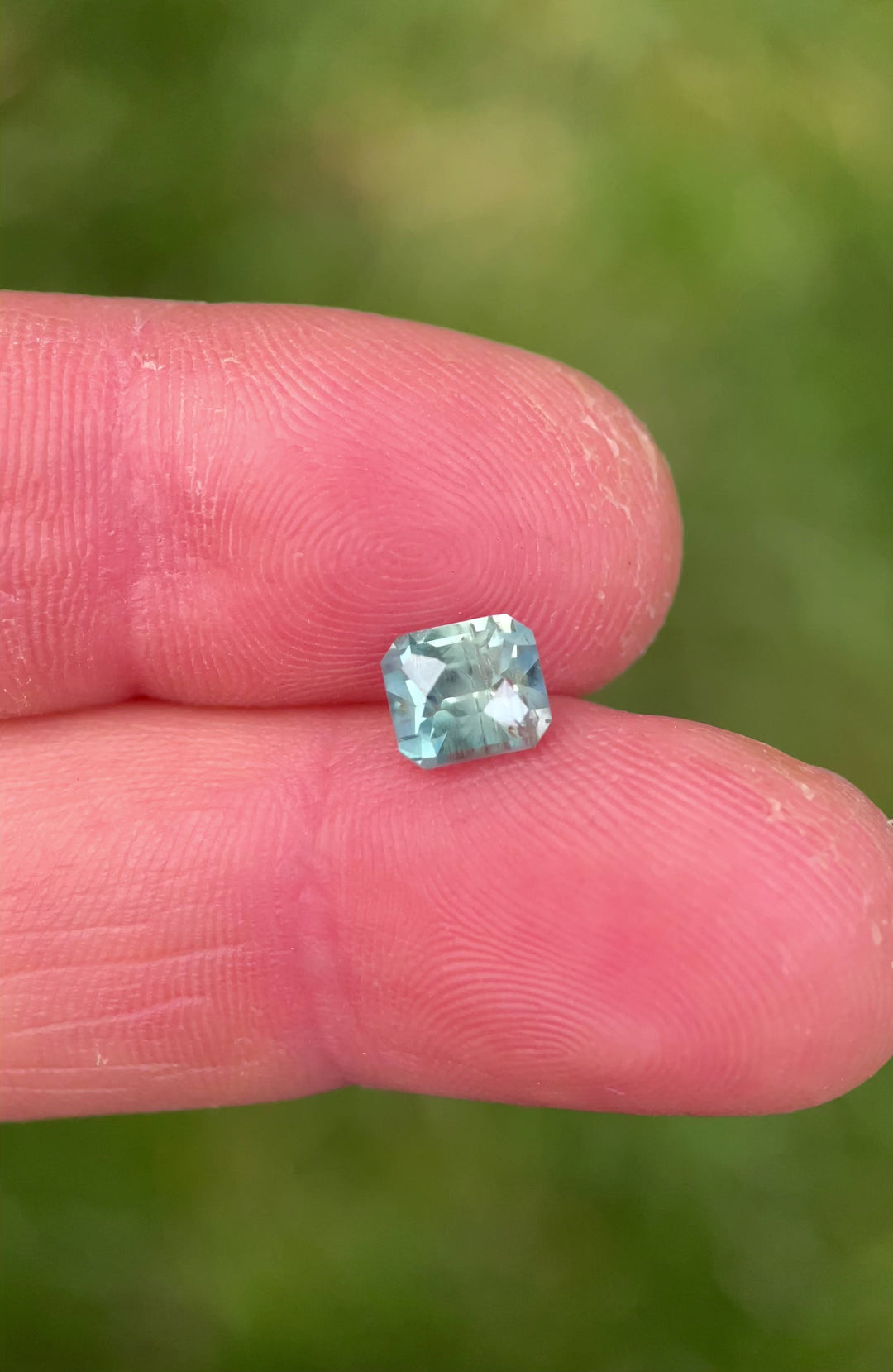 Close-up video of a 1.86ct Montana sapphire with teal and green hues, revealing brilliant light return from the custom octagonal cut.
