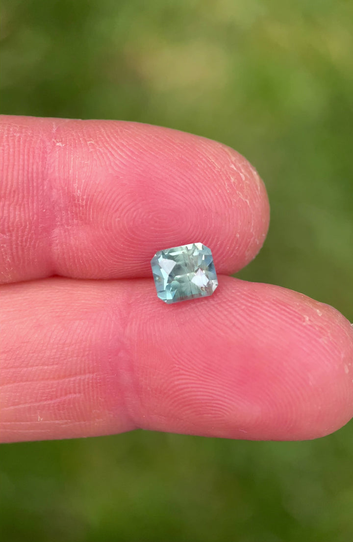 Close-up video of a 1.86ct Montana sapphire with teal and green hues, revealing brilliant light return from the custom octagonal cut.