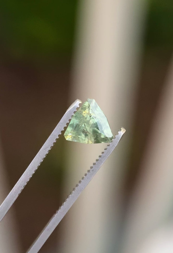 Macro video of an unheated Montana sapphire trillion cut gemstone turning under natural light, revealing color zoning, clarity features, and custom geometric symmetry.