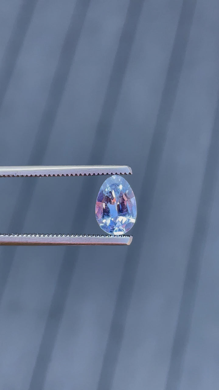 A detailed 360-degree view of a 1.74-carat Ceylon denim blue sapphire in a custom Poval cut. The video focuses on the symmetry of the gem's facets, highlighting the untreated stone's soft blue hues as it rotates. The sapphire is no-heat treated, from Sri Lanka, with dimensions of 9.18mm by 6.38mm by 3.82mm.