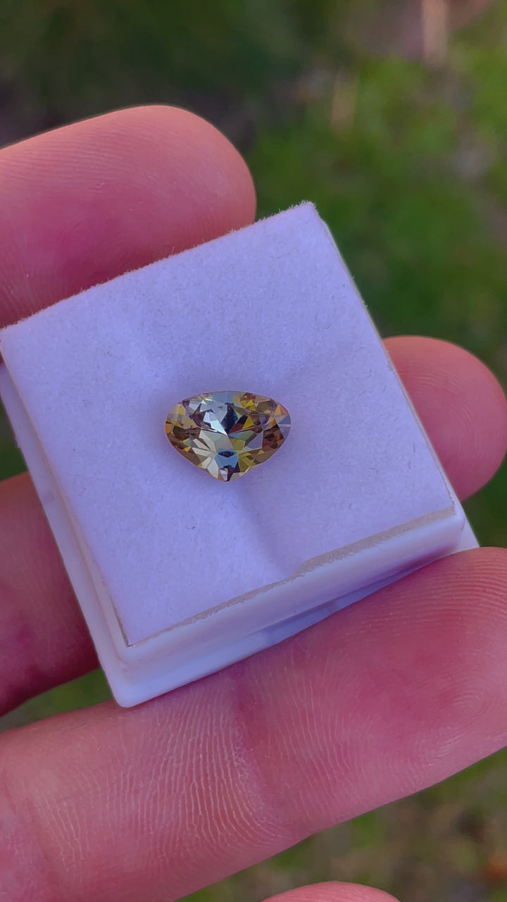 Video of a Wide Pear Brilliant Cut Tanzanite Gemstone Showcasing Teal, Gold, and Yellow Colors, Weighing 2.48 Carats, with Dimensions 8.07 x 11.16 x 4.79 mm, Originating from Merelani Hills, Arusha Region, Tanzania - No Treatment