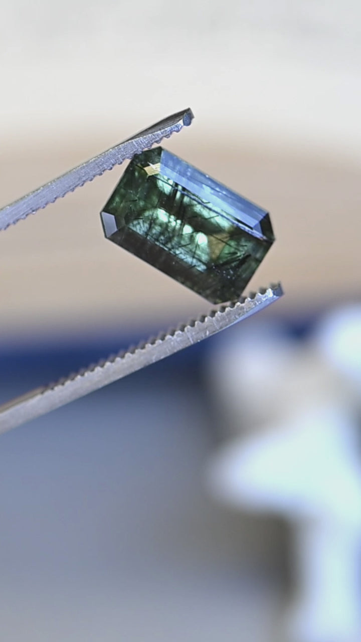 Watch this untreated 6.00 carat peridot from Skardu, Pakistan rotate in natural light, revealing its deep forest green color, elongated step mix cut, and remarkable natural needle inclusions.