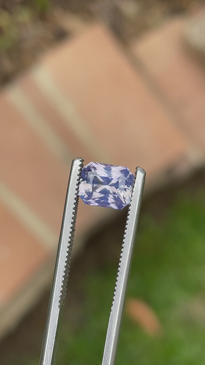 360-degree video of a 2.16-carat radiant cut sapphire from Sri Lanka, featuring shifting hues of peach, lavender, and violet under natural light.