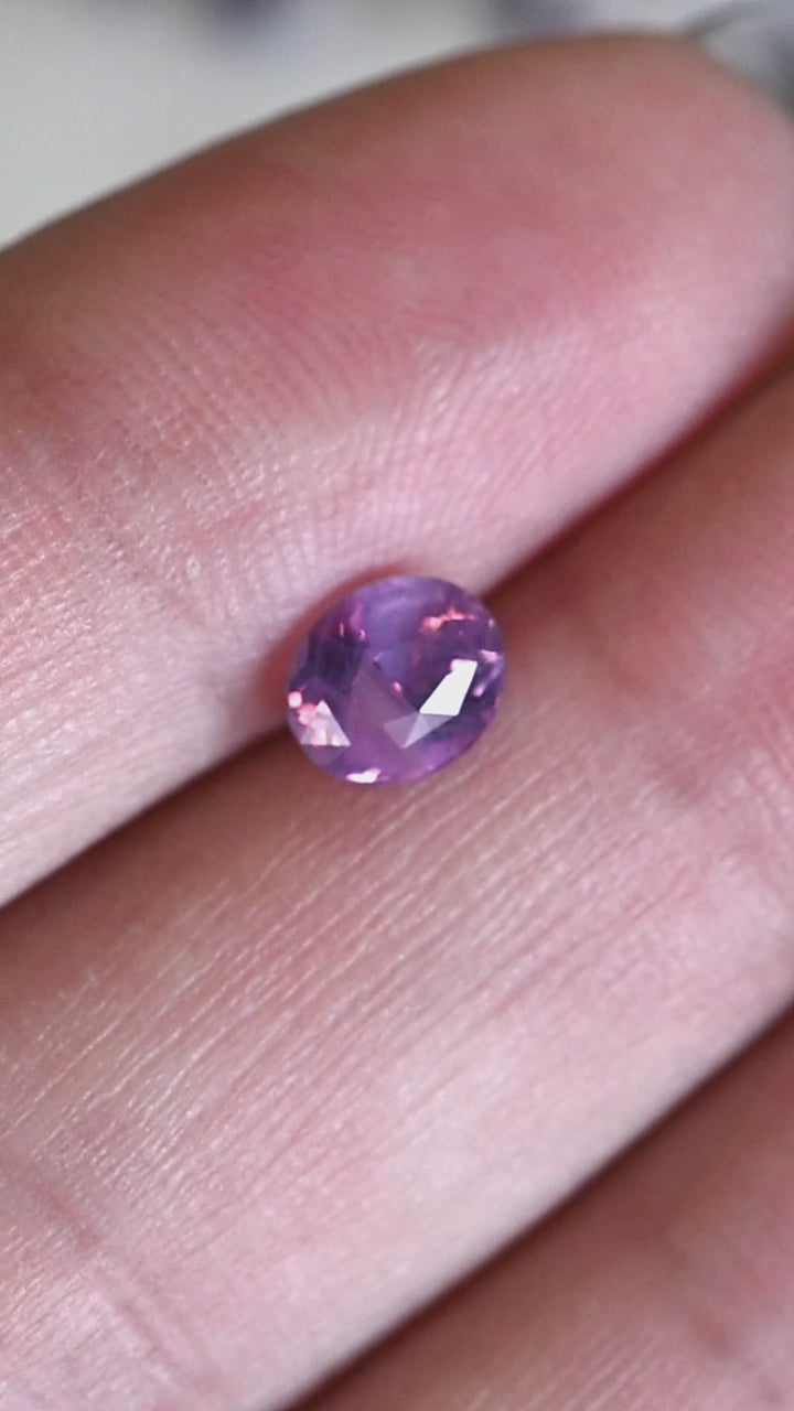 Rotating loose 1.08 carat oval purple pink sapphire showing shifting lavender and soft rose tones across the precision mix cut facets.