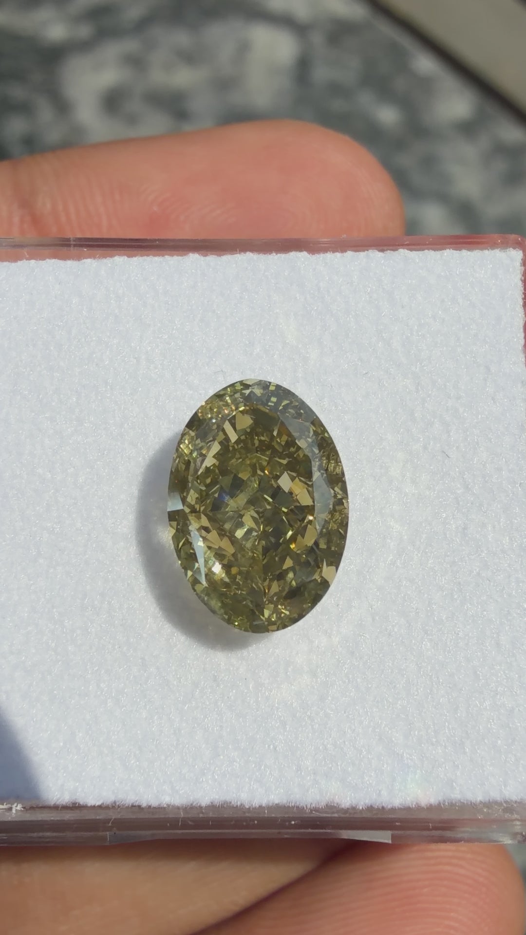 Fancy green yellow oval cut natural diamond rotating under direct sunlight