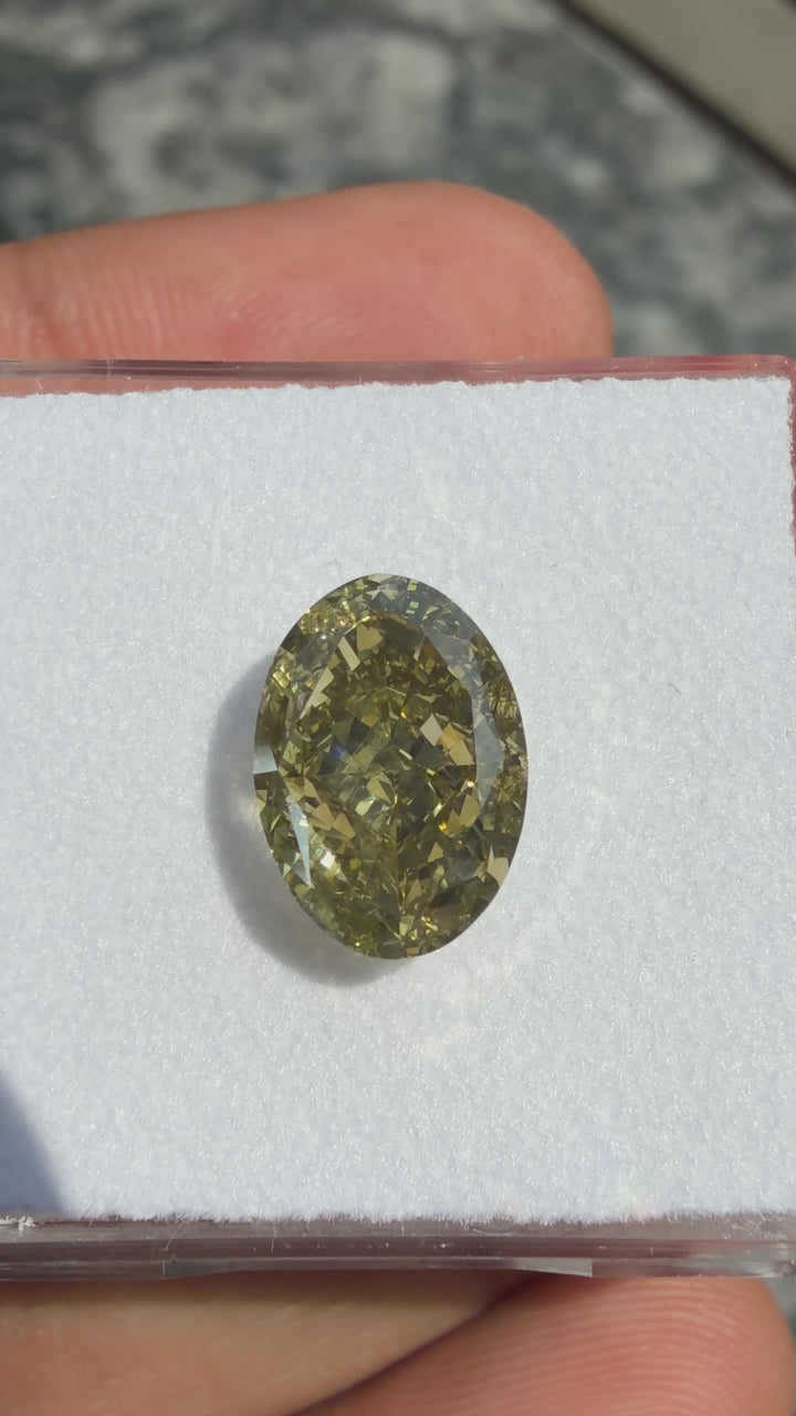 Fancy green yellow oval cut natural diamond rotating under direct sunlight