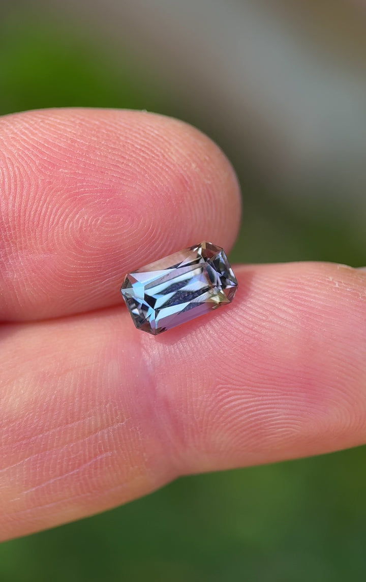 Rotating video of 2.32ct radiant-cut tanzanite gemstone, color-shifting between teal, blue, grey, and purple under natural light