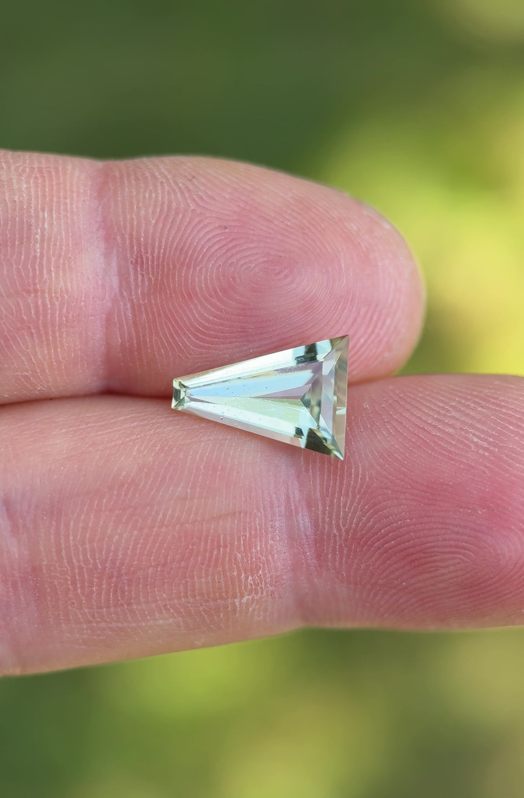 Macro close-up video of 2.02CT mint green tourmaline gemstone turning in tweezers, showing vivid pastel green color and sharp step-cut geometry, ethically sourced from Congo, Africa.