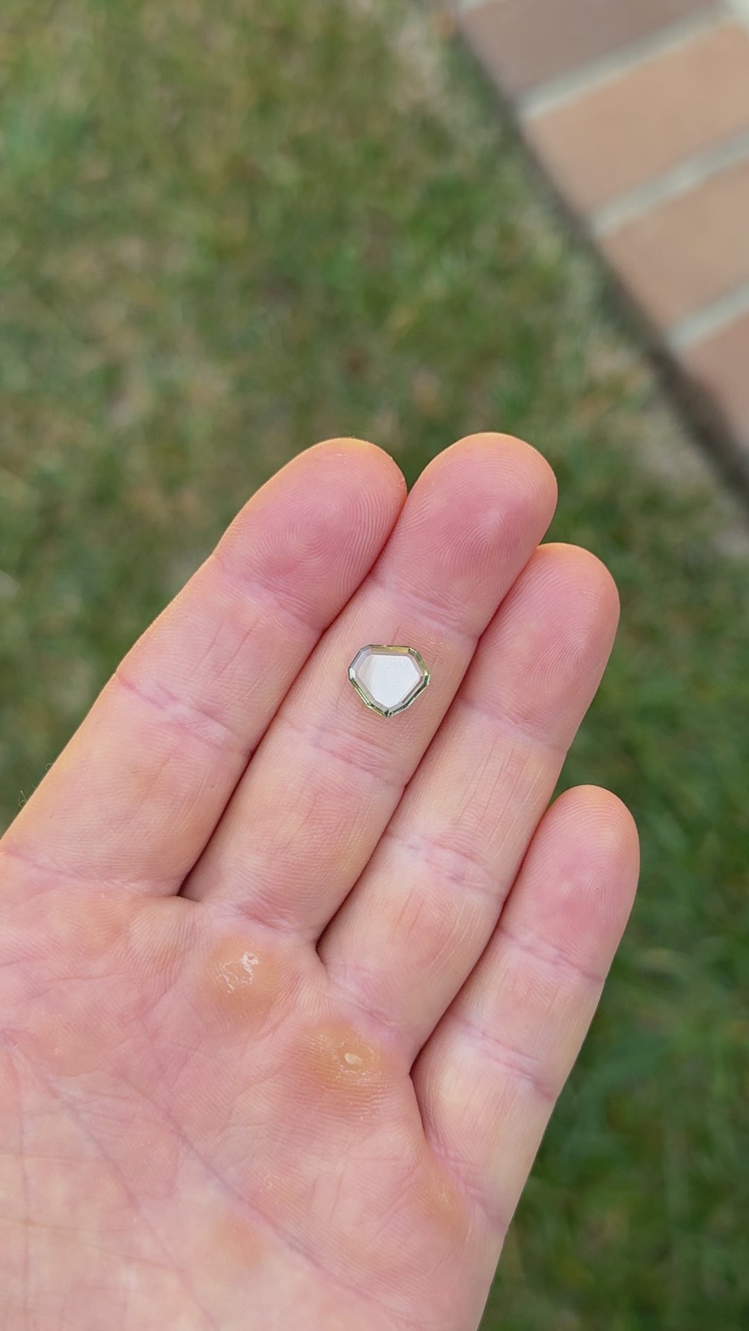 Natural light video of unheated Montana sapphire, 2.58 carats, in custom shield portrait cut showing bluish seafoam green tones