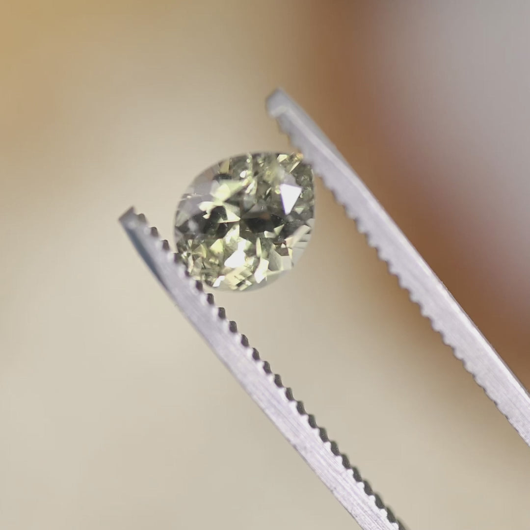 Video of a 1.45CT light teal Montana sapphire rotating in natural light, revealing the modified pear cut, sparkle, and untreated gemstone color play.