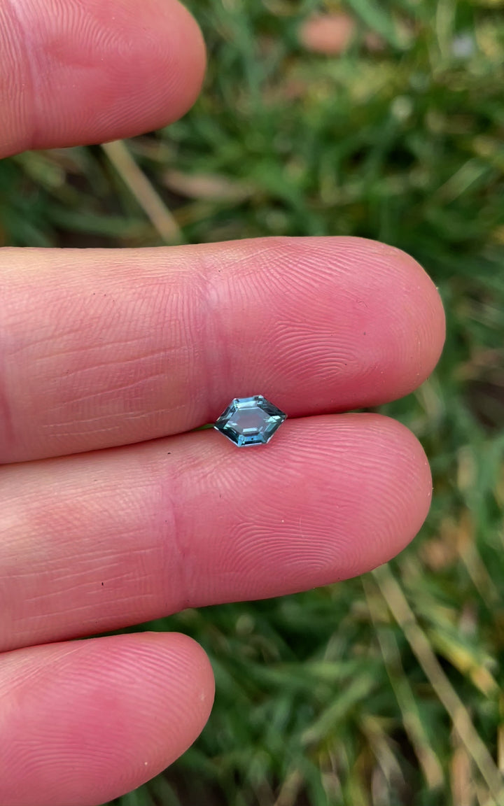 A detailed video of a 0.82-carat Montana sapphire, capturing its hexagonal open culet cut and the vibrant teal and blue hues as it reflects light.