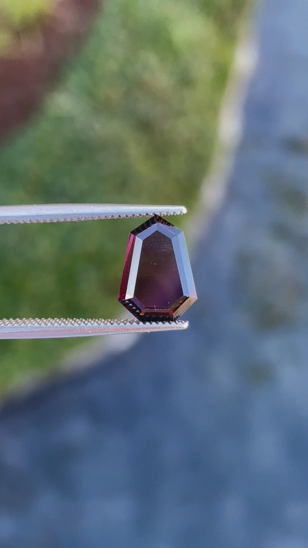 Video showcasing a 2.05 carat red-purple spinel gemstone, with a shield step cut portrait and natural untreated brilliance, sourced from Sri Lanka.