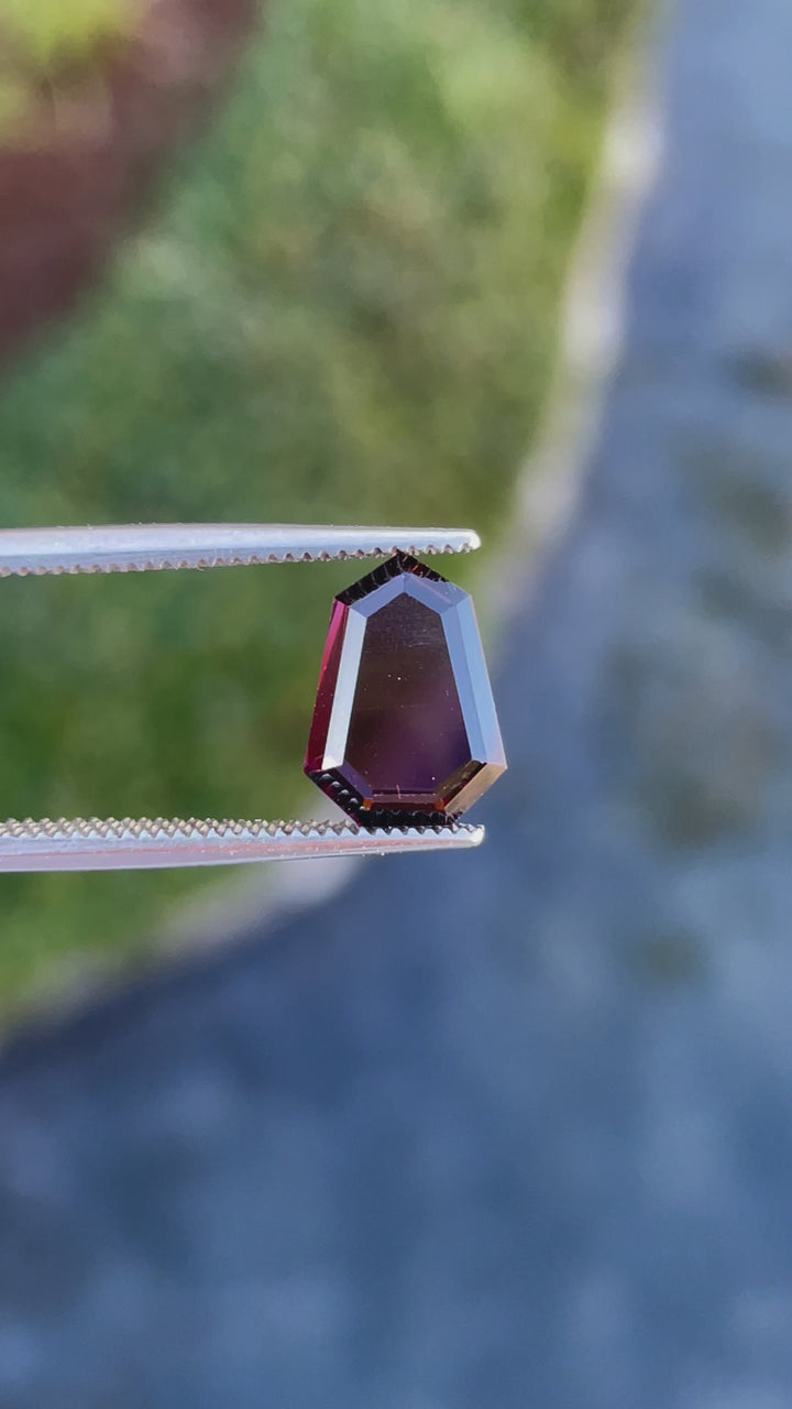Video showcasing a 2.05 carat red-purple spinel gemstone, with a shield step cut portrait and natural untreated brilliance, sourced from Sri Lanka.