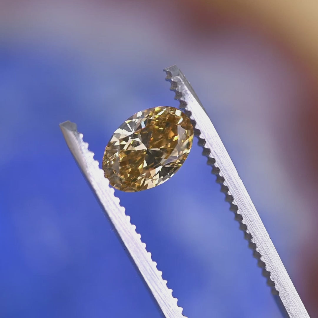 Rotating oval brown diamond showing brilliance and facet movement in natural lighting.