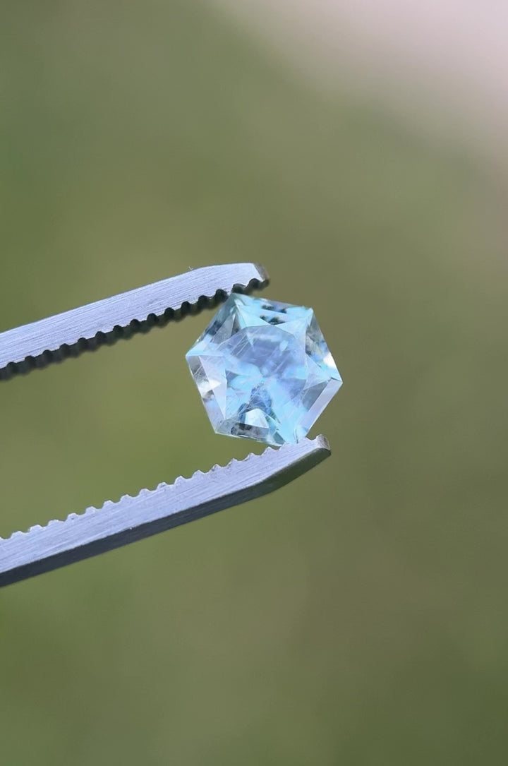 Rotating video of 1.66ct Montana sapphire showing teal and powder blue sparkle in daylight