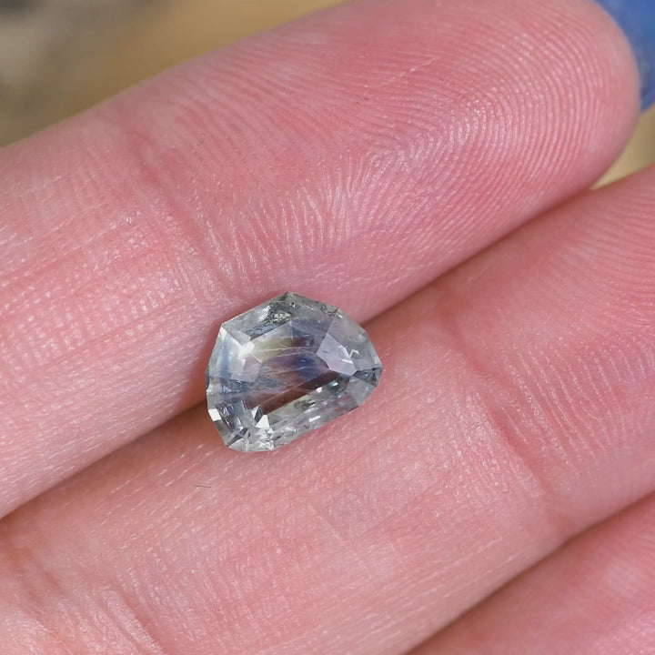 Rotating loose 2.11 carat blue teal Montana sapphire showing the reflective planes and depth of the geometric tablet cut.