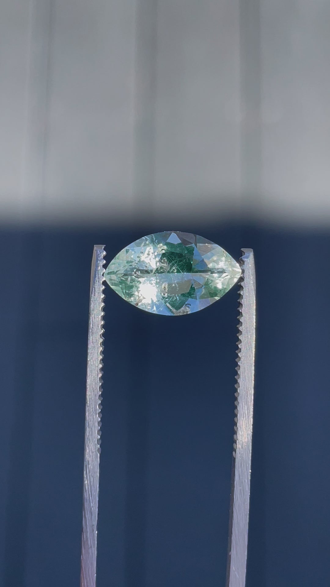 A close-up video of a 2.18-carat Hyalite Opal being rotated under natural light, highlighting its clarity and green-blue hues.