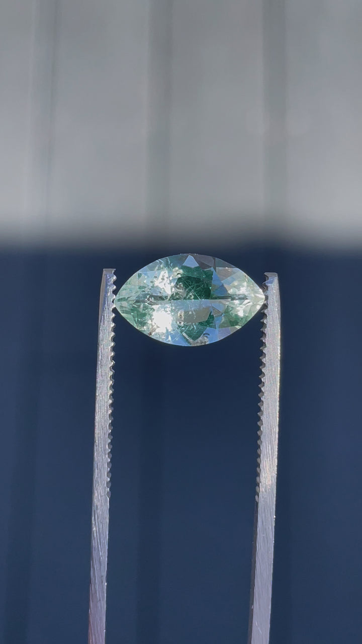 A close-up video of a 2.18-carat Hyalite Opal being rotated under natural light, highlighting its clarity and green-blue hues.