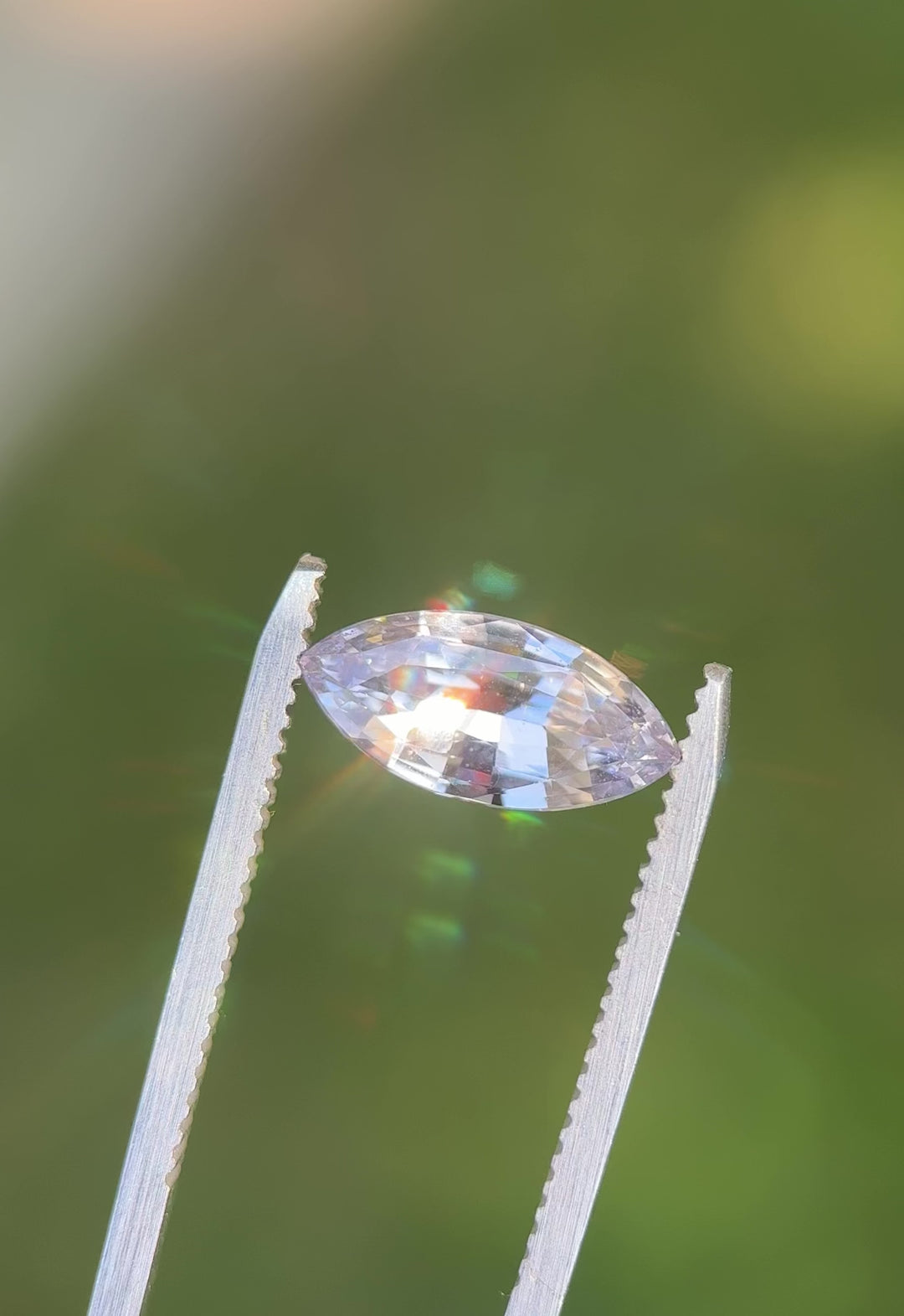 Rotating video of 2.68 carat light silvery lilac sapphire under natural sunlight, showing fine marquise mixed cut facets and subtle violet-silver color play, untreated gem from Madagascar.