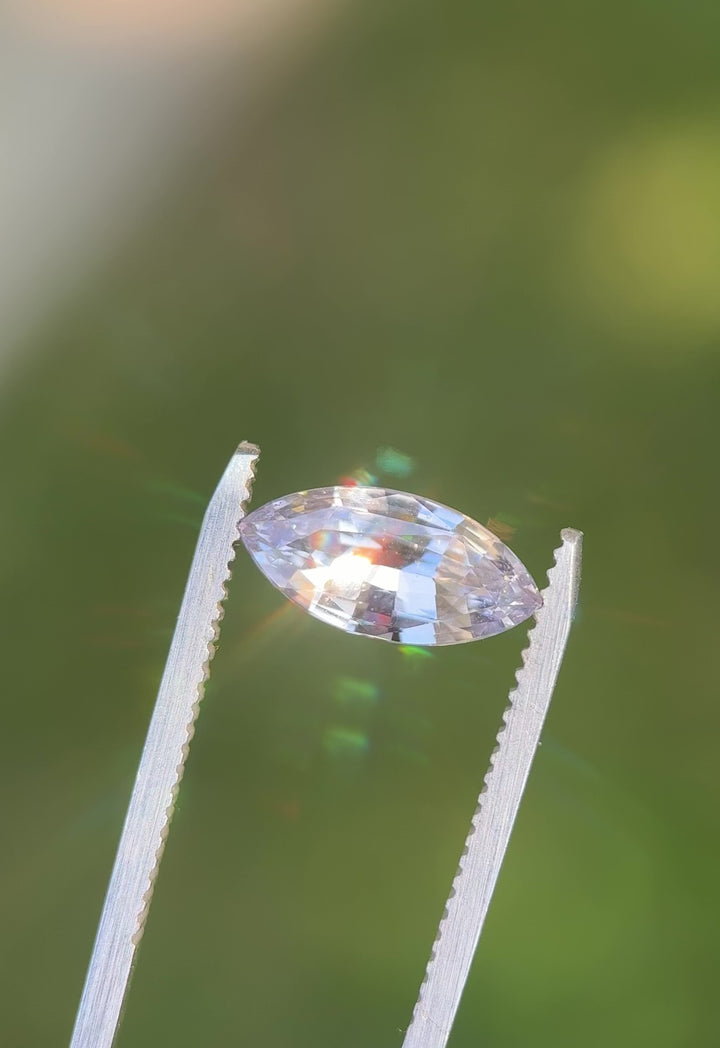 Rotating video of 2.68 carat light silvery lilac sapphire under natural sunlight, showing fine marquise mixed cut facets and subtle violet-silver color play, untreated gem from Madagascar.
