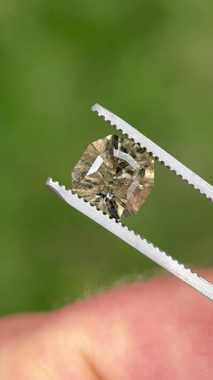 Rotating view of a 3.82ct color-changing earthy grey-green sapphire from Umba River, showing custom calf head cut and vivid color shifts.