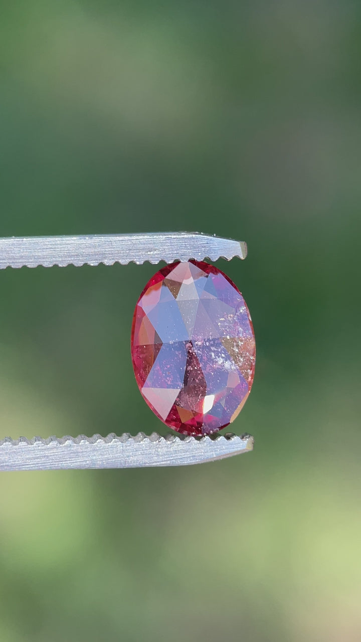 Rotating view of a 1.57-carat unheated sapphire from Umba River with orange and red colors in a custom oval cut.