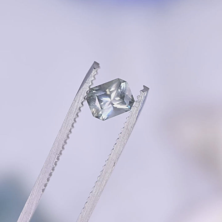 Close-up video of 0.96 carat teal gray blue Montana sapphire mixed radiant cut in motion, revealing geometric facet pattern, color depth, and natural brilliance.