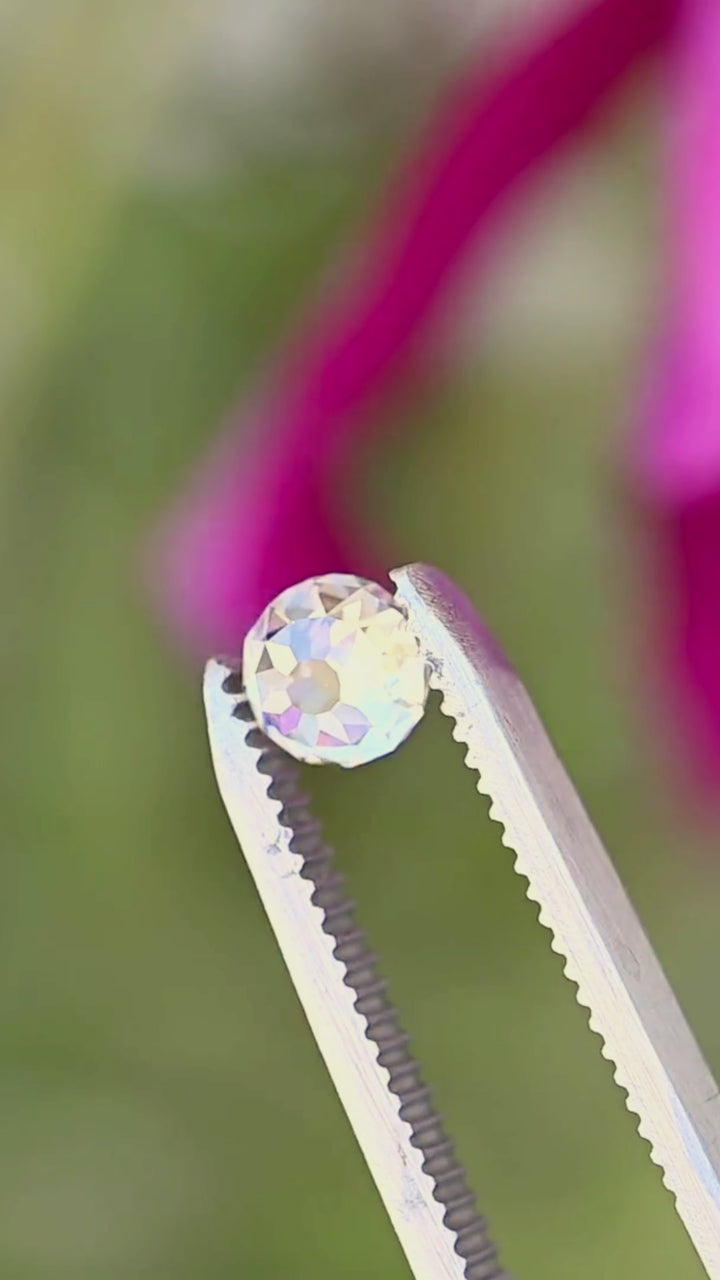 Round Mughal cut South African diamond rotated between jeweler’s tweezers, showing the movement of light across its broad antique-style faceting and dimensional profile.