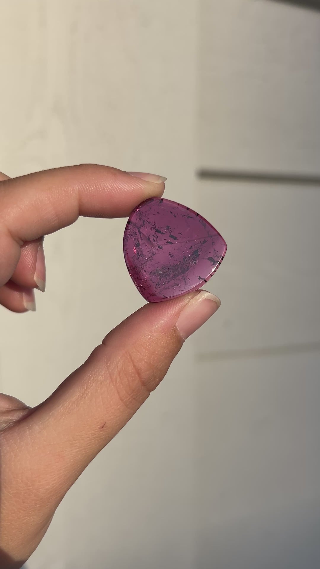 Explore the vibrant raspberry-magenta color and natural internal character of this 28.02 carat untreated pink tourmaline from Congo. Cut as a polished slice measuring 27.37 × 26.23 × 3.48 mm, the gemstone features a softly triangular silhouette and visible mineral inclusions. An expressive loose gemstone for custom pendants, statement jewelry, and contemporary one-of-a-kind designs.